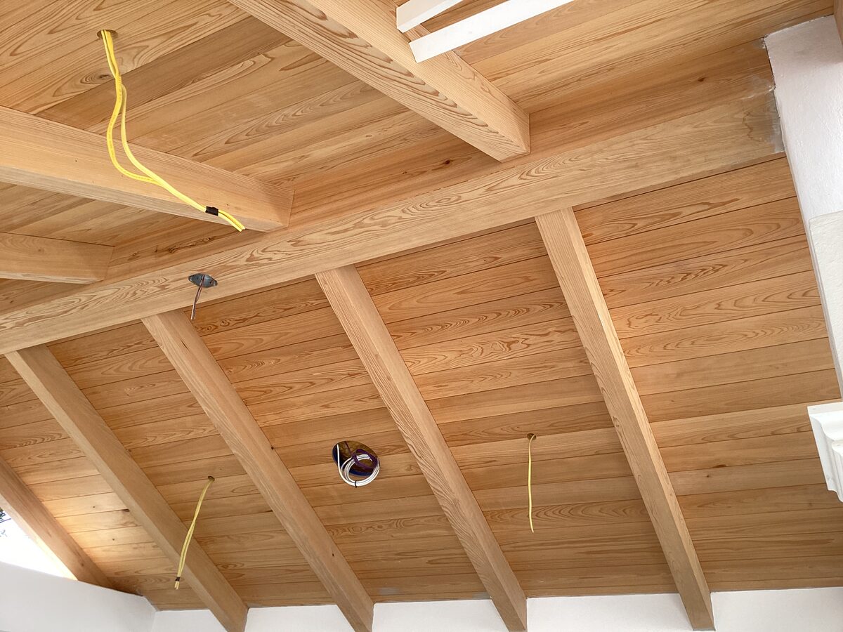Stained tongue-and-groove ceiling with exposed beams