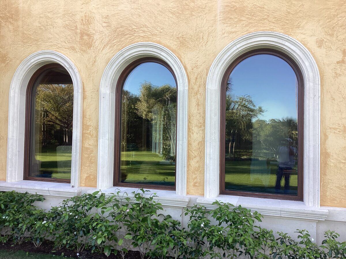Arched windows on yellow stucco facade