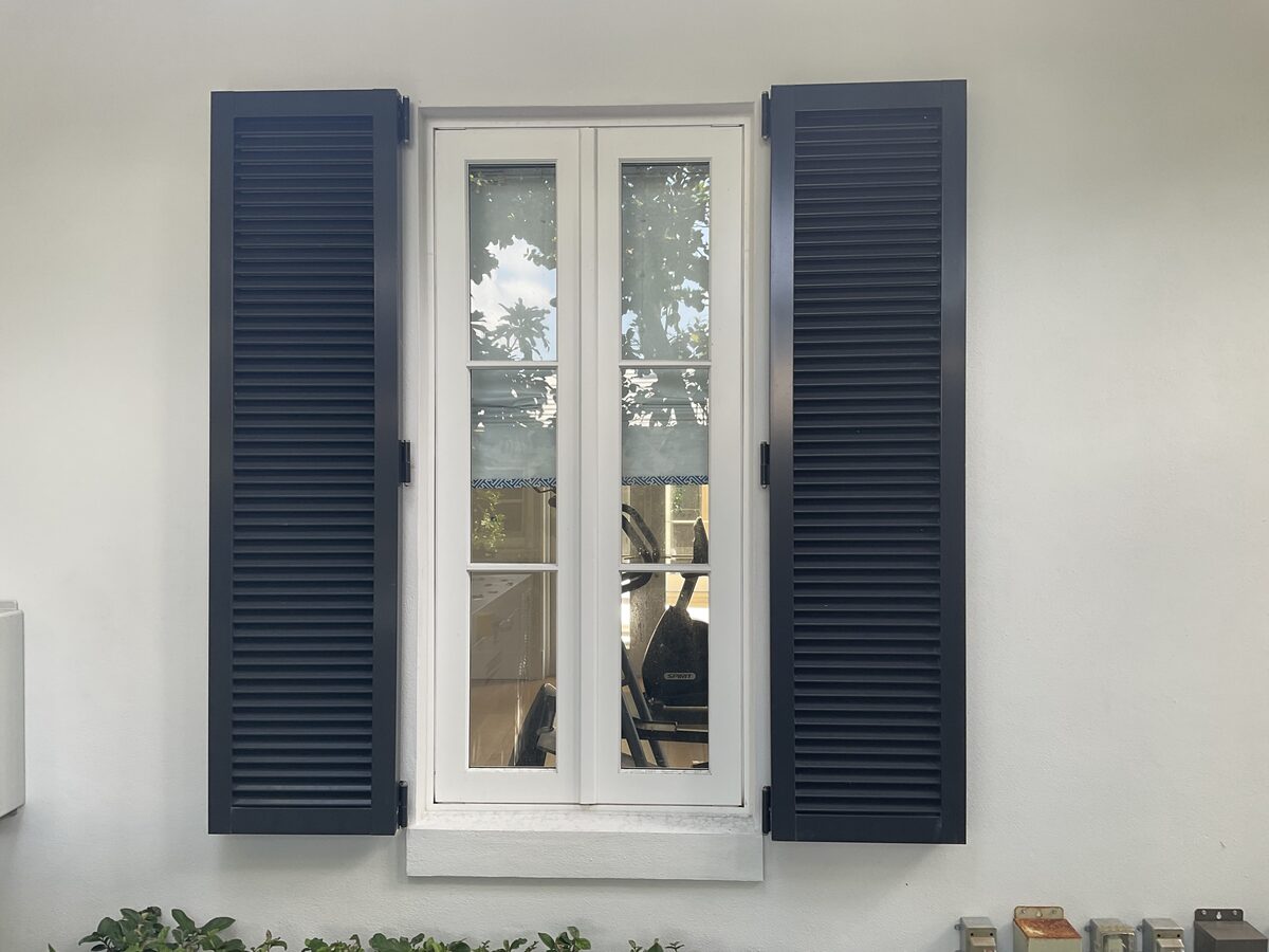 Exterior window with navy bahama shutters