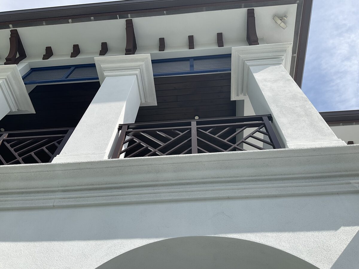 White stucco balcony detail with painted corbels