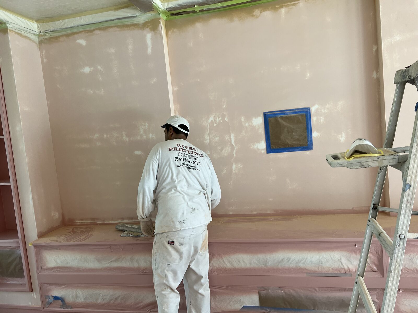 Painter troweling tinted venetian plaster onto an interior wall