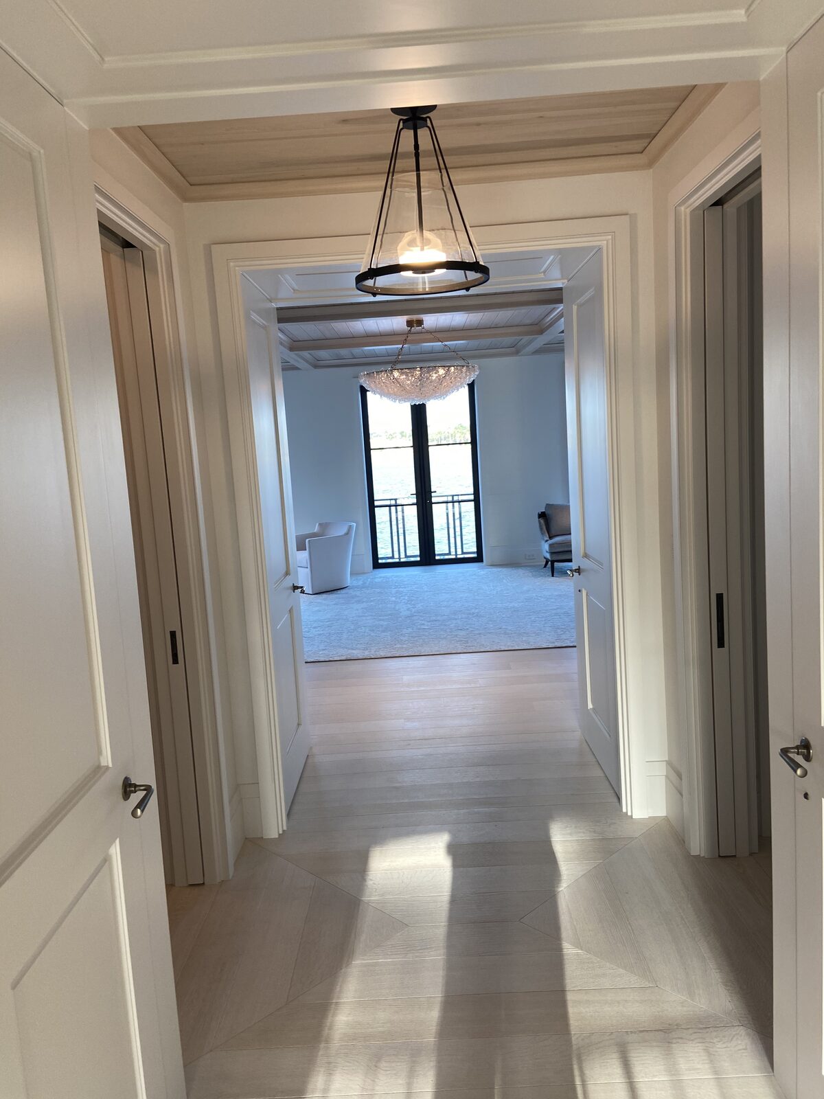 Millwork hallway sightline framing a waterfront room beyond