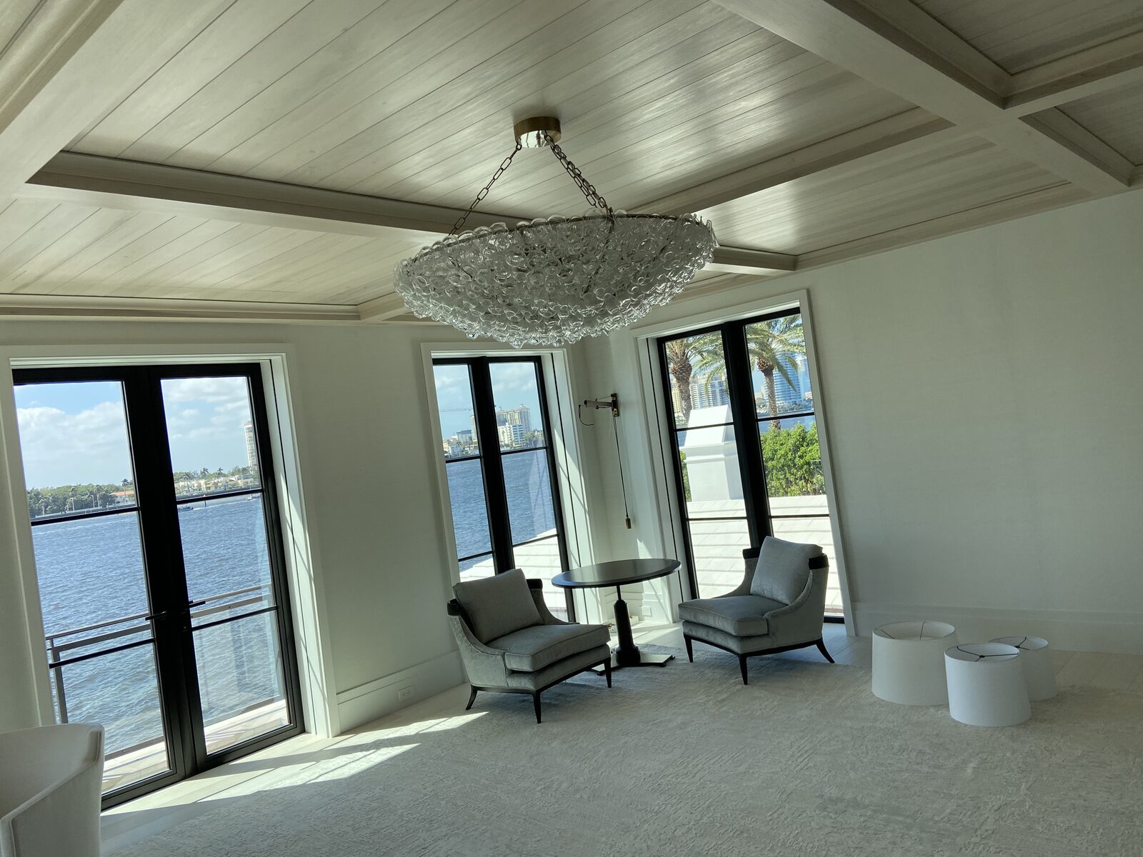 Waterfront sitting room with limed plank ceiling and glass bubble chandelier
